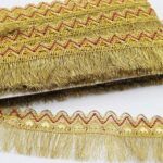 PASAMANERIA GOLD/FUCSIA 4.5 CM DE ANCHO CON FLECOS.
X 10 YARDAS.