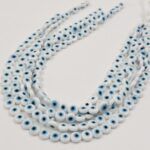 OJO TURCO DE VIDRIO 6 MM BLANCO/CELESTE.
X 1 TIRA.