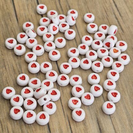 CUENTA PLÁSTICA PLANA BLANCA CORAZÓN ROJO 7MM X 500 GRS. (21-14)