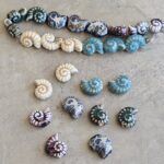 DIJE DE CERAMICA CARACOL 18*14MM X 15 UNIDADES EN TIRA SURTIDAS.(EMA 10-11)